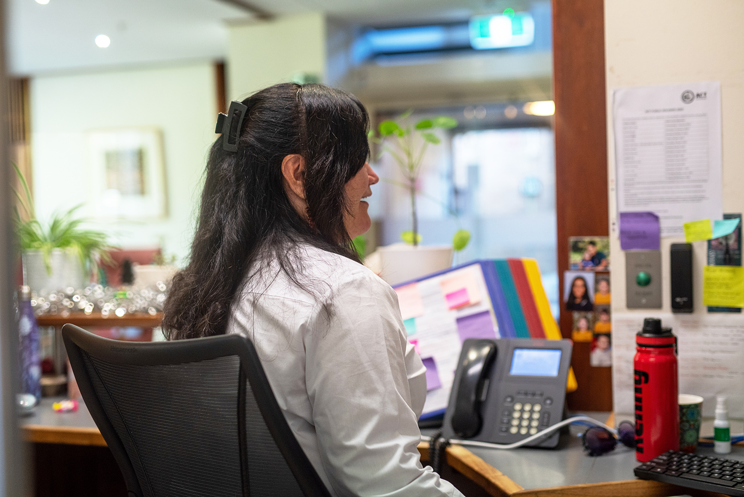 Heather Lambert, Security Professional, seated at her desk in the ������ƵChancelry Building with office equipment around her.